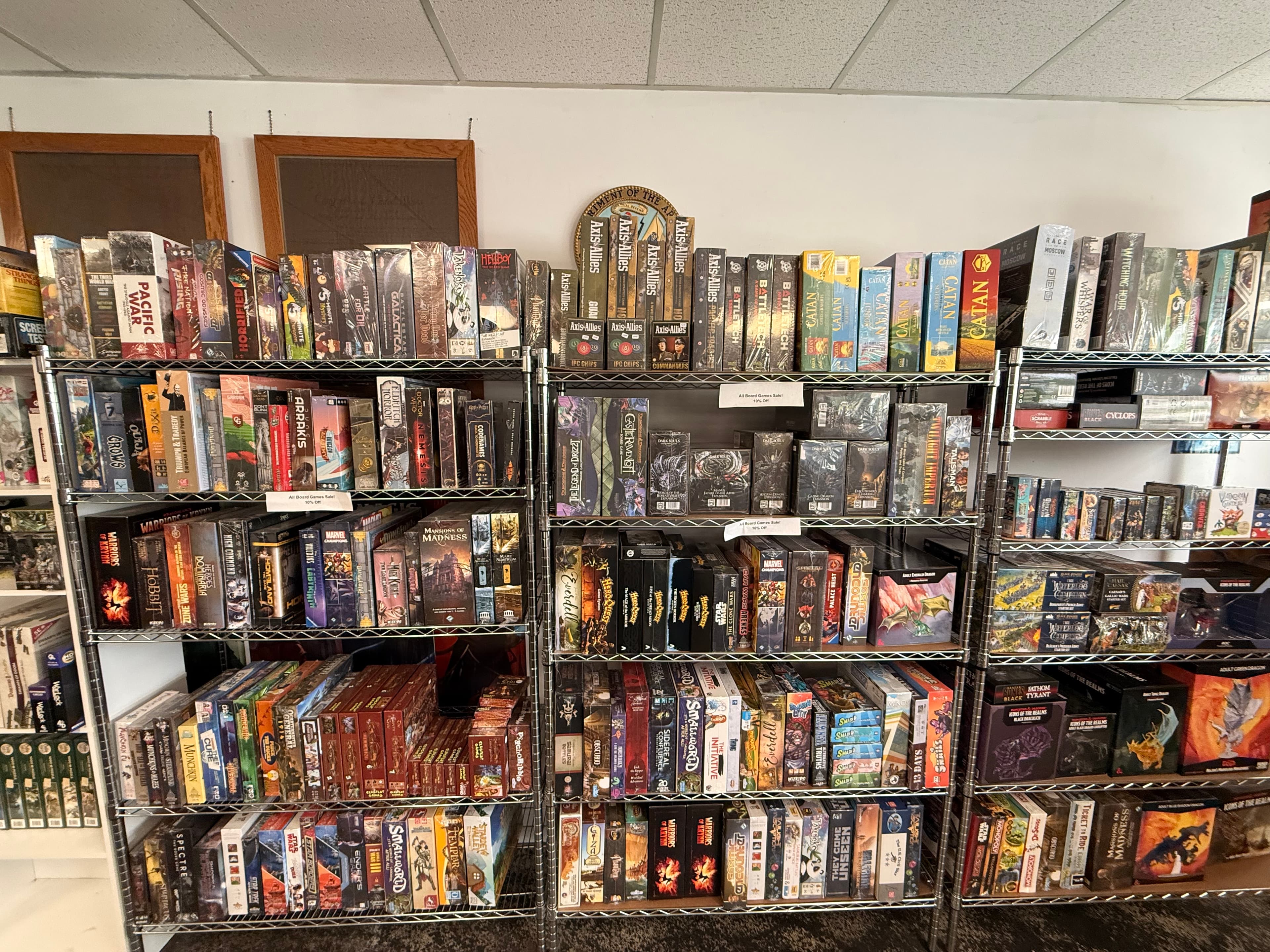 Metal wire shelves filled with a diverse collection of board games in a retail store.